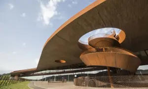 Moderna architettura di cantine in Toscana, con una scala a chiocciola in corten che si snoda sotto un tetto a sbalzo.