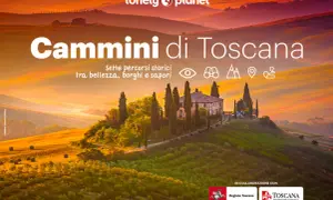 Dolci colline toscane illuminate dal tramonto, con una villa e cipressi. Titolo: "Cammini di Toscana".