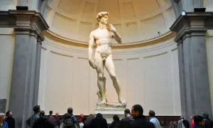 Il David di Michelangelo, capolavoro della Galleria dell'Accademia di Firenze, ammirato da visitatori.