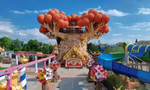 Un magico parco divertimenti in Italia con un albero gigante, scivoli acquatici e giostre colorate.