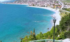 Vista panoramica delle spiagge di Reggio Calabria, con il mare cristallino che lambisce la costa e il borgo arroccato sulle colline.