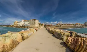 Passeggiata sul molo di Marina di Cecina, con edifici storici e stabilimenti balneari. Cosa vedere in questo angolo di Toscana.