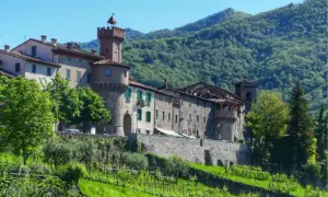 Borgo medievale con torre dell'orologio, circondato da colline verdi. Un vero gioiello, forse il paese più bello della Garfagnana.