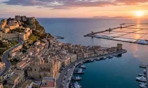 Vista aerea di Trapani al tramonto: castello, porto con barche, saline e mulini. Perfetto per scoprire cosa vedere a Trapani in 3 giorni.