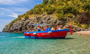Gita in barca a Marina di Camerota, con gente che si gode il mare cristallino e la costa rocciosa. Perfetto per scoprire cosa fare a Marina di Camerota.