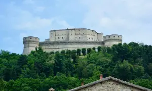 Rocche imponenti e torri rotonde dominano la collina, circondate da un verde lussureggiante. Un gioiello tra i borghi dell'Emilia Romagna.