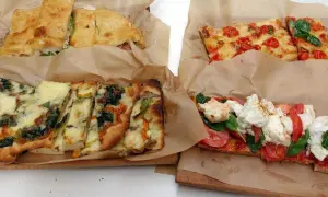 Pizza al taglio e focacce farcite, un'ottima idea per cosa mangiare a Roma. Diverse varietà con verdure, pomodoro e mozzarella.