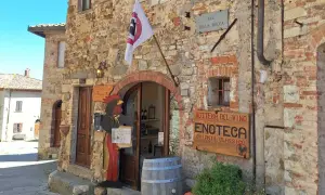 Un'enoteca in Chianti, cosa vedere: un gallo di legno accoglie i visitatori in questa bottega del vino con insegna "Chianti Classico".