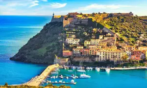 Porto Azzurro, un gioiello da scoprire tra le cose da visitare in Toscana. Un borgo colorato con un porto turistico e un'antica fortezza sul promontorio.