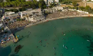 Vasta spiaggia affollata con ombrelloni e bagnanti nel mare cristallino, una delle spiagge più belle del mare di Taranto.