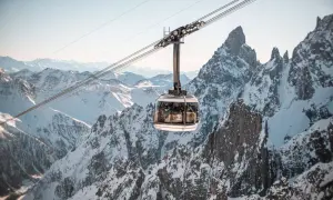 Cabina della funivia sorvola montagne innevate, un'esperienza imperdibile per scoprire Courmayeur cosa vedere.
