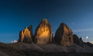 Le Tre Cime di Lavaredo illuminate dal sole al tramonto, un'idea perfetta per posti in montagna da visitare in giornata.
