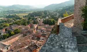 Panoramica di un borgo da visitare in Romagna, con tetti in cotto e colline verdi sullo sfondo.