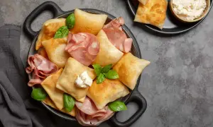 Fritti e ripieni, ecco cosa mangiare a Parma: gnocco fritto con salumi e formaggio cremoso, un'esplosione di gusto.