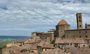 Panoramica di Volterra, con la cupola e il campanile che si stagliano sui tetti rossi. Un paesaggio toscano che ricorda San Gimignano.