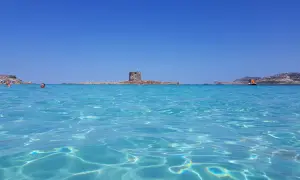 Acque cristalline e un'antica torre in mezzo al mare: uno dei tanti posti di mare belli in Italia.