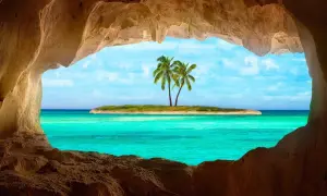 Vista da una grotta su un'isola con palme e un mare cristallino, il mare più bello del mondo.