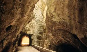 La strada della forra, un sentiero scavato nella roccia, si apre verso una luce intensa.