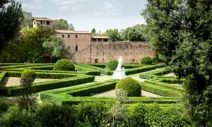 Giardini all'italiana con siepi geometriche e una statua, un assaggio di cosa vedere a San Quirico d'Orcia.
