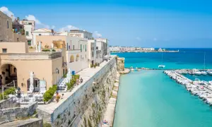Otranto cosa vedere: un borgo bianco affacciato sul mare turchese, con un porto pieno di barche e un lungomare da sogno.