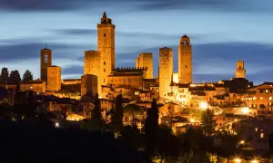 San Gimignano, una delle città da visitare in Toscana, illuminata di notte con le sue iconiche torri medievali.