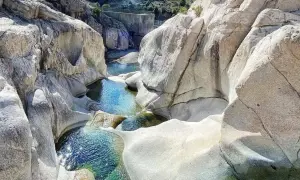 Pozzo di roccia con acqua cristallina, un luogo ideale per rinfrescarsi tra le cascate in Sardegna dove fare il bagno.