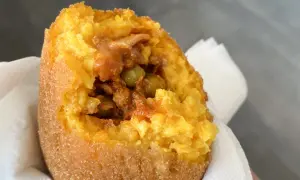 Arancino al ragù, un classico da provare se ti chiedi cosa mangiare a Catania. Croccante fuori, saporito dentro.