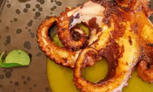 Tentacoli di polpo grigliato su crema verde, un'ottima idea su cosa mangiare ad Agrigento per un'esperienza culinaria indimenticabile.