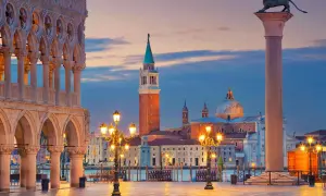 Piazza San Marco Venezia al tramonto, con il Palazzo Ducale, il Campanile e la Basilica di San Giorgio Maggiore illuminati.