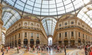 La Galleria Vittorio Emanuele II, un capolavoro architettonico con vetrate luminose e negozi di lusso, accoglie visitatori a Milano.
