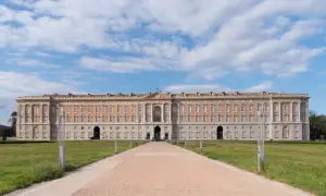 Reggia di Caserta, la piazza più grande d'Italia, con il suo imponente palazzo reale e un viale che conduce verso l'ingresso principale.