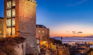 Torre medievale illuminata al tramonto, con vista sul porto e sul mare. Perfetto per scoprire cosa vedere a Cagliari in 3 giorni.