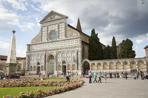Piazza Santa Maria Novella, uno dei luoghi da vedere a Firenze, con la sua facciata rinascimentale e un prato fiorito.