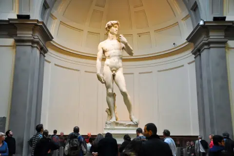Il David di Michelangelo, capolavoro della Galleria dell'Accademia di Firenze, ammirato da visitatori.