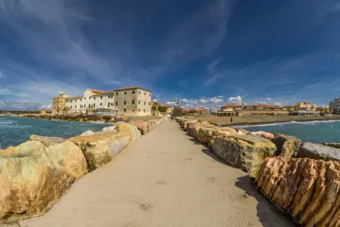 Passeggiata sul molo di Marina di Cecina, con edifici storici e stabilimenti balneari. Cosa vedere in questo angolo di Toscana.