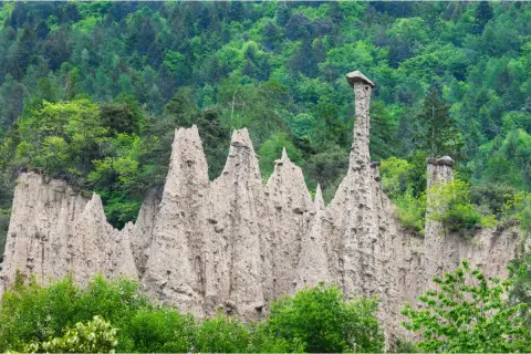 Piramide di terra nel Val di Cembra, con un cappello di pietra in cima a una delle formazioni.