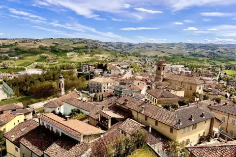 Panoramica di Castagnole delle Lanze, con tetti rossi e colline verdi. Cosa vedere: il borgo e i vigneti circostanti.