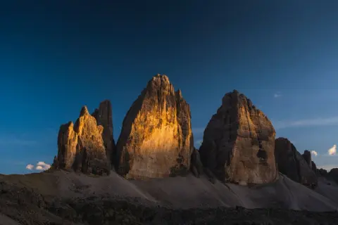 Le Tre Cime di Lavaredo illuminate dal sole al tramonto, un'idea perfetta per posti in montagna da visitare in giornata.