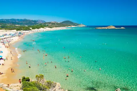La spiaggia più bella della Sardegna, con sabbia dorata, acque cristalline e tante persone che si godono il sole e il mare.
