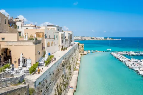 Otranto cosa vedere: un borgo bianco affacciato sul mare turchese, con un porto pieno di barche e un lungomare da sogno.