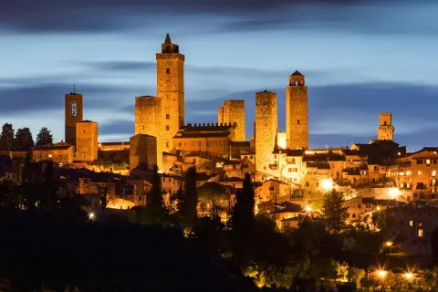 San Gimignano, una delle città da visitare in Toscana, illuminata di notte con le sue iconiche torri medievali.