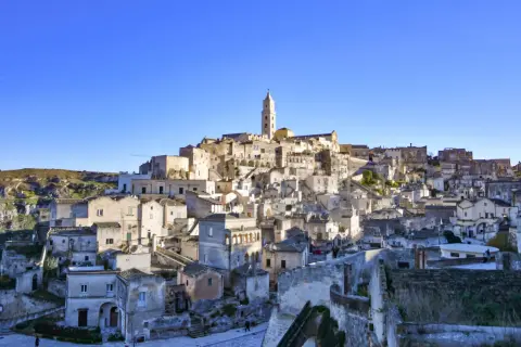 Panoramica dei Sassi di Matera, un labirinto di case scavate nella roccia, con indicazioni visive che guidano attraverso questo sito UNESCO.