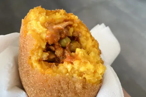 Arancino al ragù, un classico da provare se ti chiedi cosa mangiare a Catania. Croccante fuori, saporito dentro.