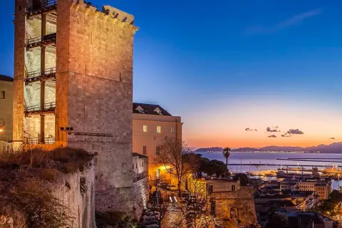 Torre medievale illuminata al tramonto, con vista sul porto e sul mare. Perfetto per scoprire cosa vedere a Cagliari in 3 giorni.