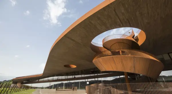 Moderna architettura di cantine in Toscana, con una scala a chiocciola in corten che si snoda sotto un tetto a sbalzo.
