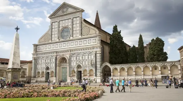 Piazza Santa Maria Novella, uno dei luoghi da vedere a Firenze, con la sua facciata rinascimentale e un prato fiorito.