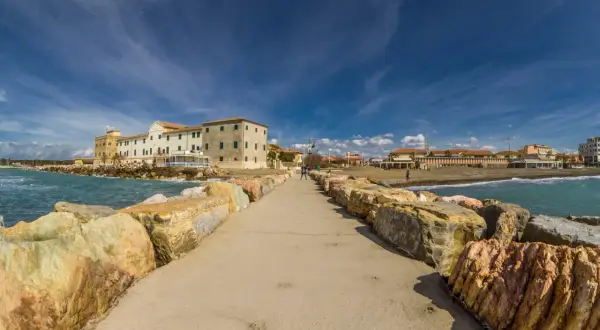 Passeggiata sul molo di Marina di Cecina, con edifici storici e stabilimenti balneari. Cosa vedere in questo angolo di Toscana.
