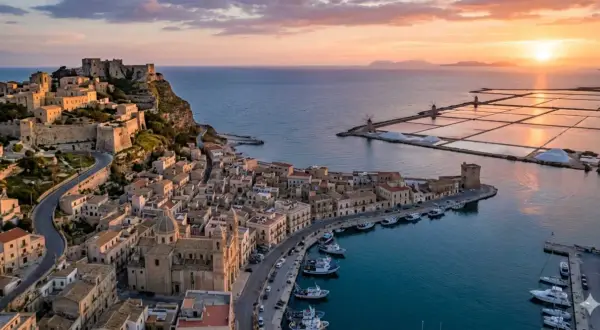 Vista aerea di Trapani al tramonto: castello, porto con barche, saline e mulini. Perfetto per scoprire cosa vedere a Trapani in 3 giorni.