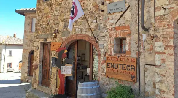Un'enoteca in Chianti, cosa vedere: un gallo di legno accoglie i visitatori in questa bottega del vino con insegna "Chianti Classico".