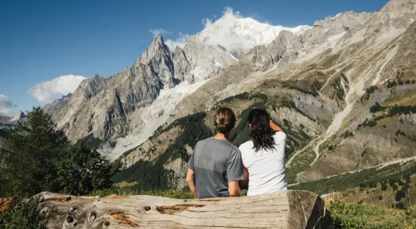 Coppia ammira maestose vette innevate in Val Ferret, godendosi la tranquillità dopo passeggiate facili.
